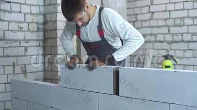 工作中的年轻建筑工人在建筑工地上穿着积木